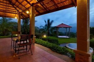 a patio with a table and chairs under a pergola at Monica Farms - Monica Retreat in Waki