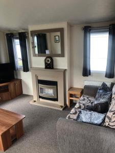 sala de estar con sofá y chimenea en Eyemouth getaway, en Eyemouth