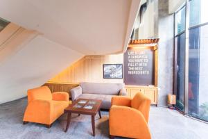 sala de estar con sillas de color naranja y sofá en Adika Hotel Bahtera, en Klandasan Kecil