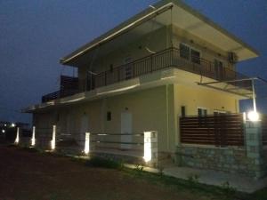 a house with a balcony and lights in front of it at Nereids Apartments-Pronoe in Petalidhion
