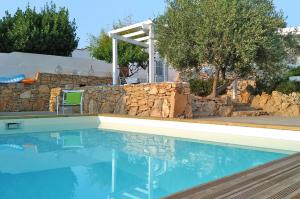 a swimming pool in a yard with a stone wall at Villa La Samia in Torricella +27 photos
