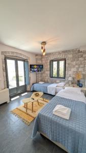 um quarto com 2 camas e uma parede de pedra em Sabaton Apartment em Leonidio