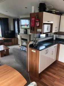 cocina y sala de estar con sofá y mesa en Eyemouth getaway, en Eyemouth