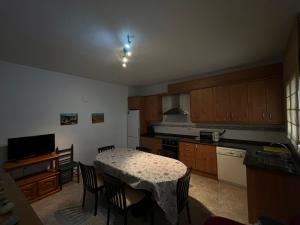 a kitchen with a table and chairs and a kitchen with a table and a kitchen at Casa Rural Angeles in Catí +12 photos