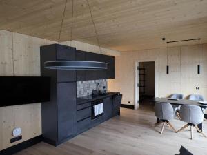 a kitchen with black cabinets and a table with chairs at Beautiful apartment in Mieders in a sunny location in Mieders