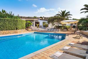a swimming pool with chairs and a house at Cala Mancina in San Vito lo Capo
