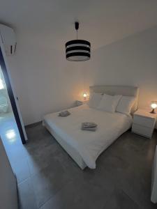 a bedroom with a white bed with two towels on it at Villa LEOVI Superbe logement 3 pieces - 7 personnes, à 100m plage la Faviere in Bormes-les-Mimosas