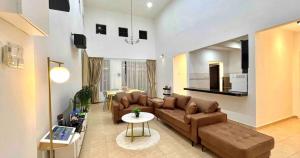 A'Famosa Bungalow*Private Garden Stage*22Pax*NEW في Kampong Ulu Pegoh: غرفة معيشة مع أريكة وطاولة