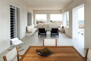 ein Wohnzimmer mit einem Tisch und Stühlen in der Unterkunft Villa Capo Passero in Portopalo