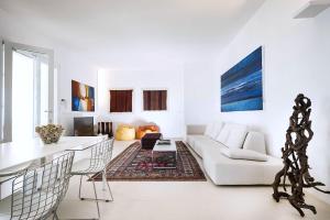 ein weißes Wohnzimmer mit einem Sofa und einem Tisch in der Unterkunft Villa Capo Passero in Portopalo