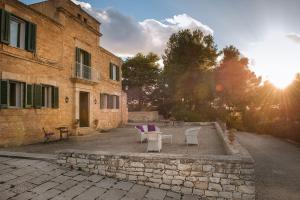 twee stoelen en een tafel voor een gebouw bij Corte del Sale in Paceco
