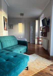 una sala de estar con un sofá verde en una habitación en Rezydencja Kapitańska - Morska 2, en Kołobrzeg