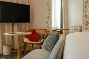 1 dormitorio con 1 cama, 1 mesa y 1 silla en Sofitel Roma Villa Borghese, en Roma