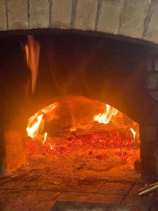 a pizza is being cooked in a brick oven at Prroni's Rooms in Shkodër