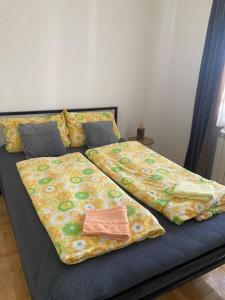 un letto con due coperte e cuscini sopra di Tea a Sremska Mitrovica Altre 34 foto