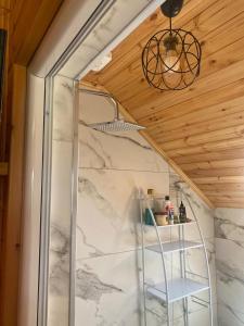 a walk in shower with a white marble wall at Prroni's Rooms in Shkodër