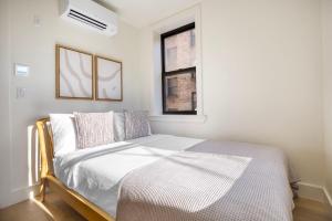 um pequeno quarto com uma cama e uma janela em Blueground East Village elev wd near park NYC-1462 em Nova York