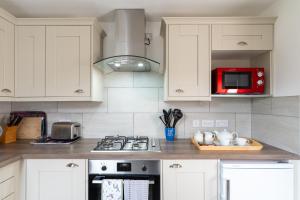 a kitchen with white cabinets and a red microwave at BELLE VUE - SKIPTON in Skipton