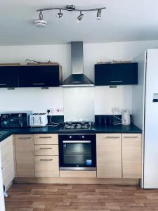 a kitchen with a stove and a refrigerator at Alba, 2 Bed Flat, by Grays Station, Free Parking in Stifford