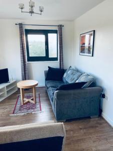 a living room with a couch and a table at Alba, 2 Bed Flat, by Grays Station, Free Parking in Stifford