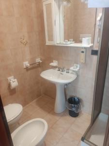 a bathroom with a white sink and a toilet at Albergo Aurora in Canzolino