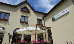 a white umbrella in front of a building at Hotel Ana in Arad