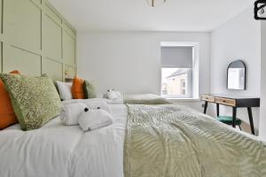 uma cama branca com um ursinho de peluche em North Road Luxe New Serviced Apartments- Parking Available with Full Kitchen Amenities em Cardiff