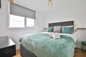um quarto com uma cama grande e uma janela em North Road Luxe New Serviced Apartments- Parking Available with Full Kitchen Amenities em Cardiff