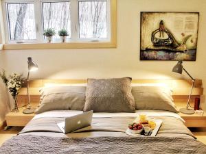 a bed with a laptop and a bowl of fruit on it at Destination Franc Sud Gaspésie in Cascapedia