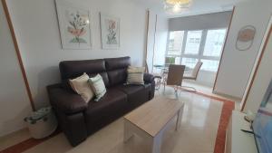 a living room with a leather couch and a table at Mirasol in Viveiro