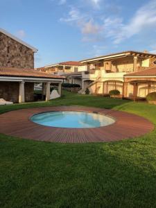 een groot huis met een zwembad in het midden van een tuin bij LOTUS Wellness Apartment - Resort Ginestre - Palau - Sardinia in Palau