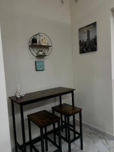 a table and two stools next to a wall at Little B&B in Caserta