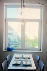 a table with chairs and a window in a room at Au Béguinage - Studio au coeur de wavre in Wavre