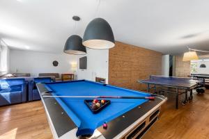 a pool table in a living room with two ping pong tables at Maison Montagne in Samedan