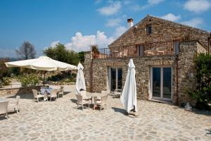 a patio with umbrellas and chairs and a building at Rupe Alta Home in Castellabate
