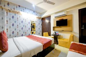 pokój hotelowy z dwoma łóżkami i telewizorem w obiekcie Airport Hotel Ark View w Nowym Delhi