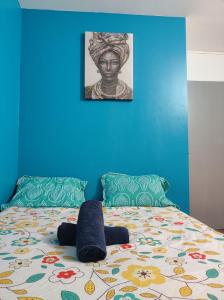 1 dormitorio con 1 cama con pared azul y cabecero en Paris cosy private room with shared space - Chambre privée avec espace commun Paris, en Vitry-sur-Seine