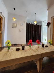 una camera con tavolo in legno e fiori in vaso di Serenity Inn home stay a Srinagar