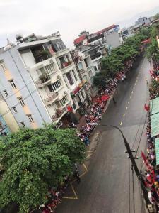 a street with a crowd of people on the side of the road at A Thía Hostel in Dien Bien Phu