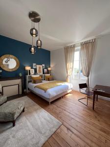 1 dormitorio con cama, mesa y espejo en Le Clos Gabrielle en Châtellerault