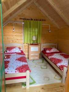 a bedroom with two beds in a log cabin at Estate Vukadinovic in Mojkovac