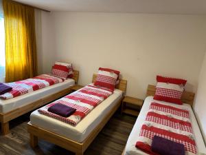 a room with two beds with red and white blankets at 2 Bedroom Apartment - Matten in Matten