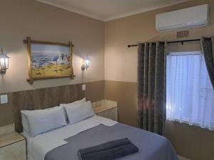 莫科帕内Sleep 'n Go Guesthouse的带床和窗户的卧室