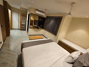a bedroom with two beds and a television in it at Nova Park in Rajkot