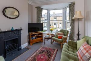 a living room with a fireplace and a television at CRAVEN VUE - SKIPTON in Skipton