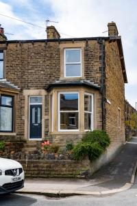 a brick house with a car parked in front of it at CRAVEN VUE - SKIPTON in Skipton