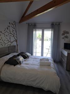 ein Schlafzimmer mit einem großen Bett und einem Fenster in der Unterkunft le chemin des Bérands chambres d'hôtes Renaison in Renaison
