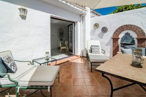 un patio con mesa y sillas y una zona al aire libre. en AB2 - Aldea Blanca Marbella by Roomservices, en Marbella