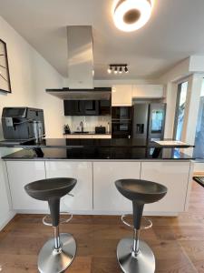 ブクステフーデにあるExklusives Penthouse in Buxtehude !!のカウンター前のバースツール2脚付きキッチン
