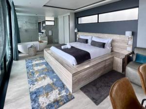 - une chambre avec un grand lit et une baignoire dans l'établissement Ntomb'lele Ocean View Luxury Holiday Villas, à Tugela Mouth
